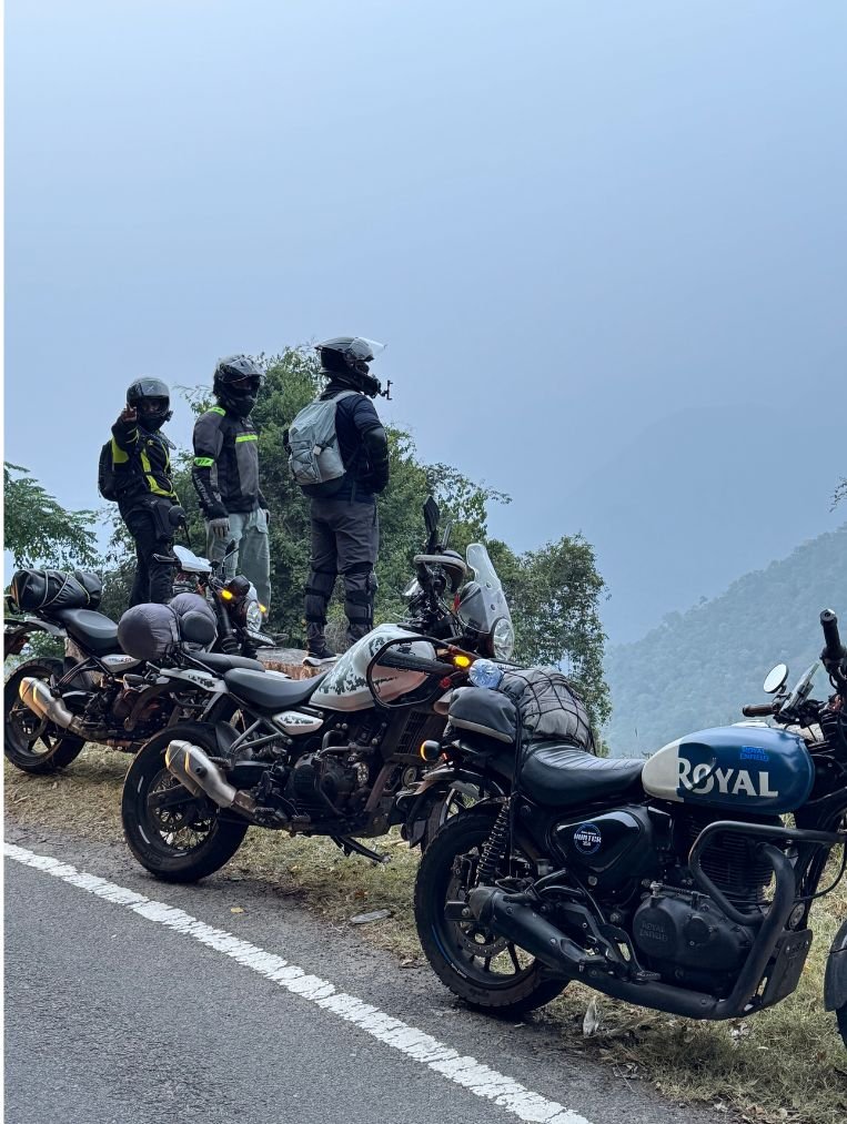 Motorcycle convoy on a winding Himalayan road in Uttarakhand