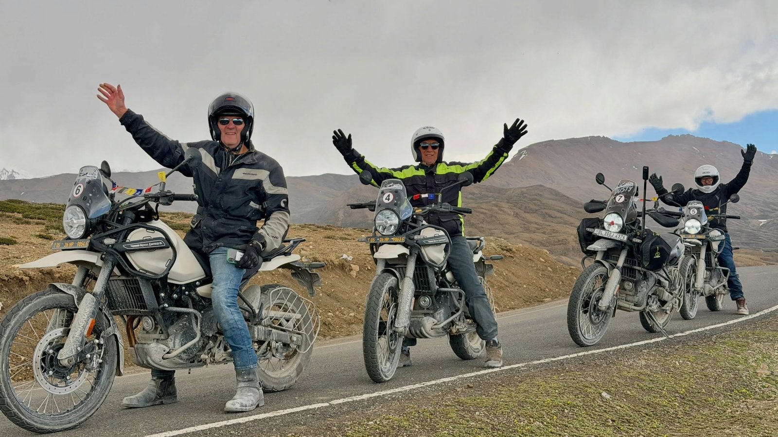 Motorcycles riding a winding Himalayan mountain road at golden hour